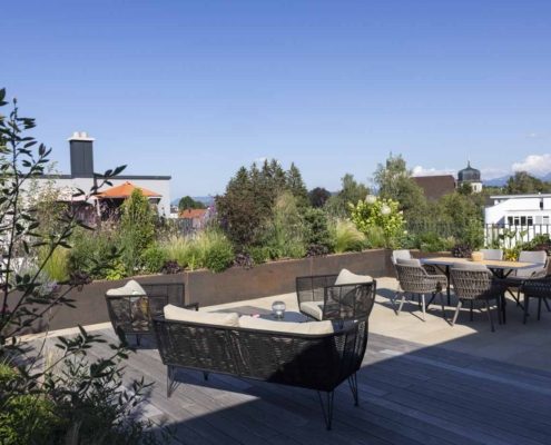 Moderner Dachgarten in Lindenberg Moderner Dachgarten in Lindenberg im Allgäu mit großzügiger Holzterrasse, Lounge-Möbeln, Essbereich und üppig bepflanzten Hochbeeten.